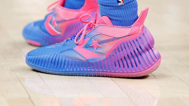 View of pink and purple Converse shoes.